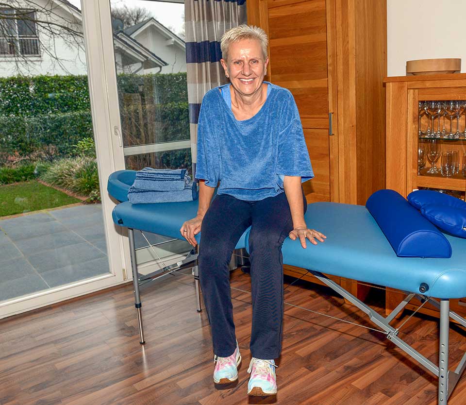 Dietlind Schumann auf einer Behandlungsliege sitzend